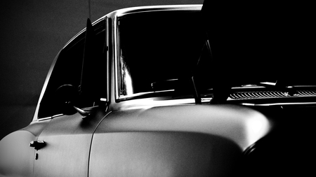 Viewing down the body line of a car with chrome trim illuminated.